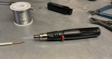 Gaslötkolben mit Flamme auf der Werkbank