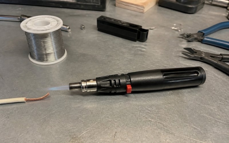 Gaslötkolben mit Flamme auf der Werkbank